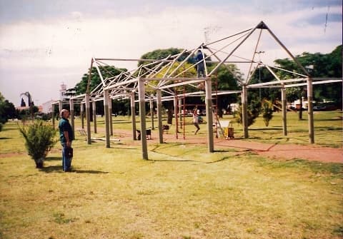 Parque con palmeras, banco azul y césped